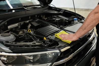 Photo of Man wiping auto engine with rag at car wash, closeup