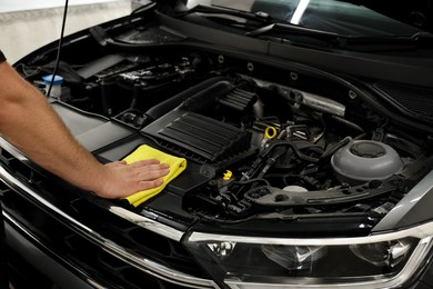 Photo of Man wiping auto engine with rag at car wash, closeup