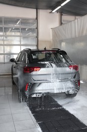 Washing auto with high pressure water jet at car wash, closeup