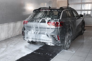 Washing auto with high pressure water jet at car wash, closeup