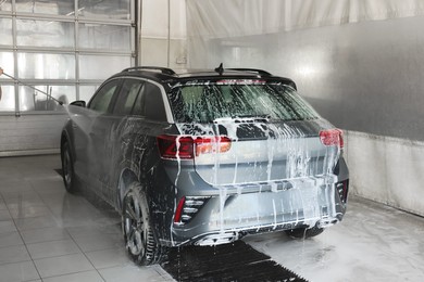 Washing auto with high pressure water jet at car wash, closeup