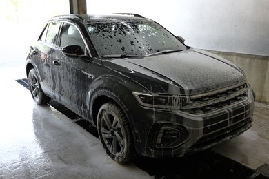 Auto covered with cleaning foam at car wash