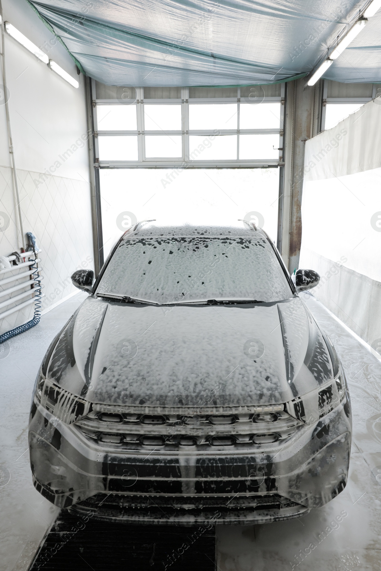 Photo of Auto covered with cleaning foam at car wash