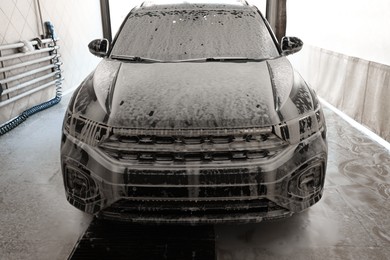 Photo of Auto covered with cleaning foam at car wash