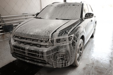 Auto covered with cleaning foam at car wash