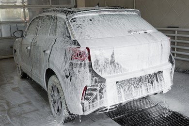 Auto covered with cleaning foam at car wash