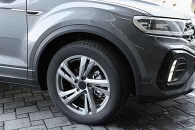 Modern grey car parked on paved road, closeup