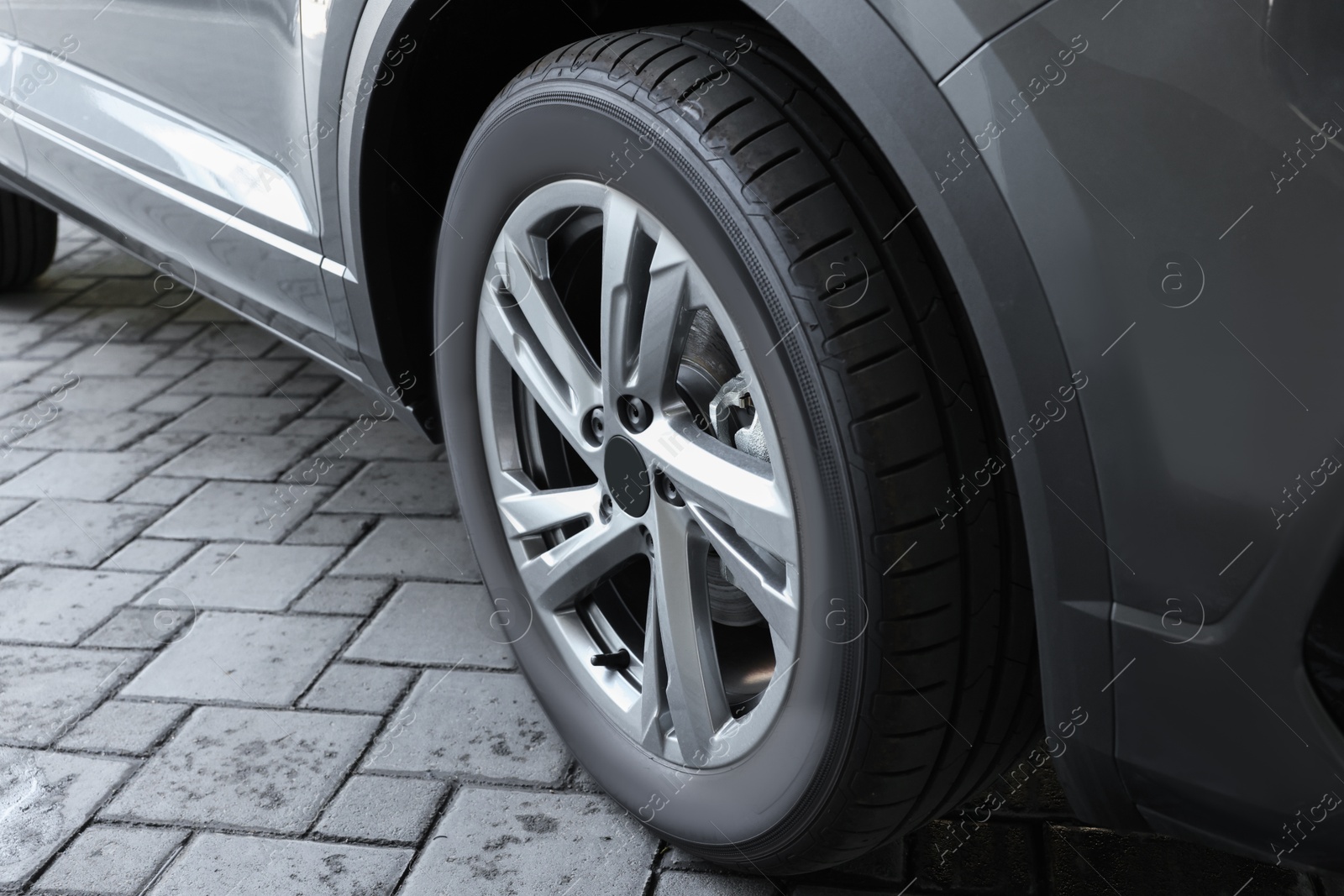 Photo of Modern grey car parked on paved road, closeup