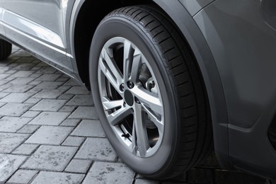 Modern grey car parked on paved road, closeup