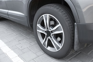 Photo of Modern grey car parked on paved road, closeup