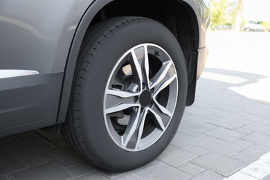 Photo of Modern grey car parked on paved road, closeup