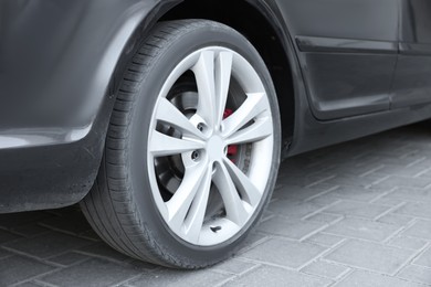 Modern black car parked on paved road, closeup