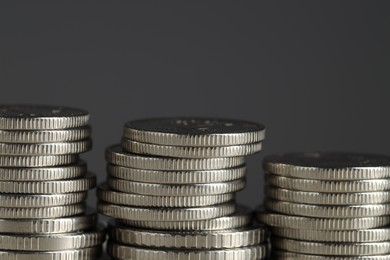 Photo of Stacked coins on grey background, closeup. Salary concept