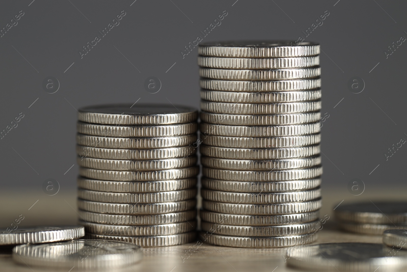 Photo of Stacked coins on table against grey background, closeup. Salary concept