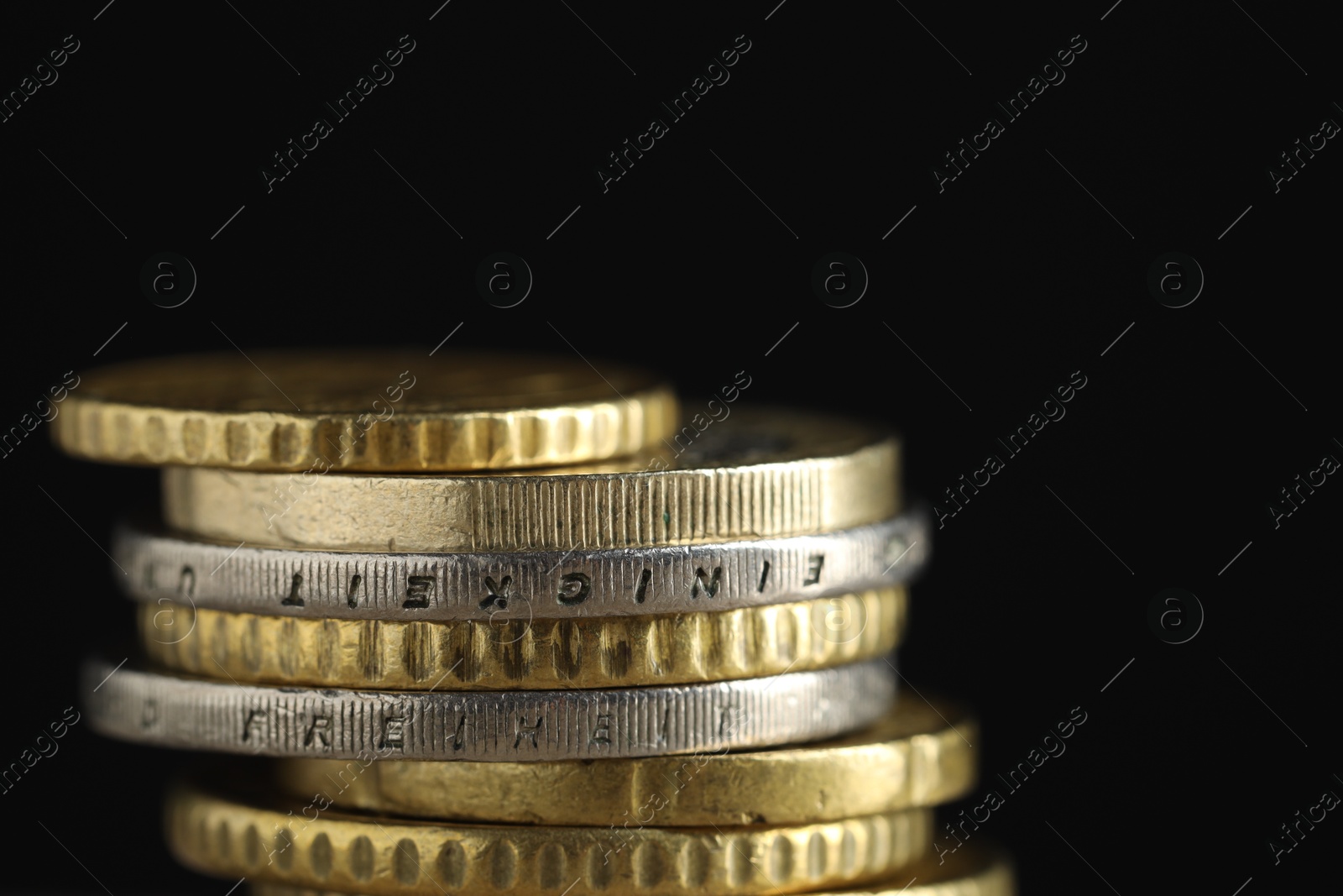 Photo of Stack of coins on black background, closeup. Salary concept