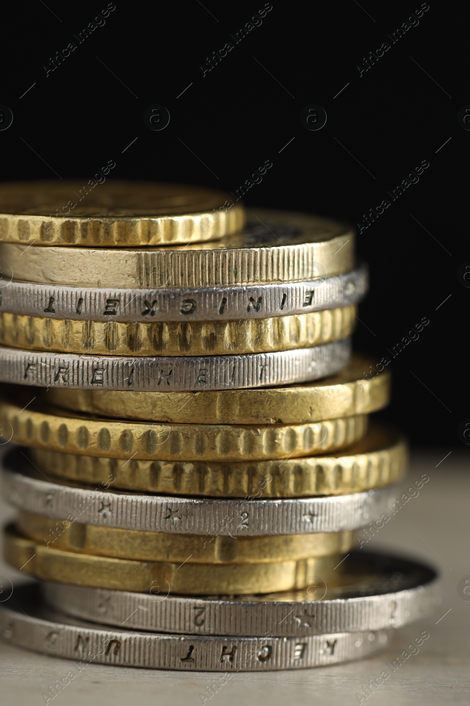 Photo of Stack of coins on table against black background, closeup. Salary concept