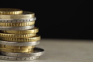 Photo of Stack of coins on table against black background, closeup with space for text. Salary concept