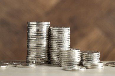 Photo of Stacked coins on light table, closeup. Salary concept