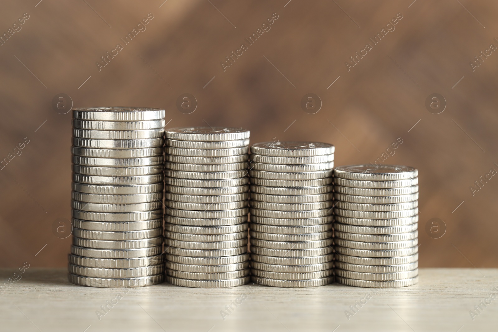 Photo of Stacked coins on light table, closeup. Salary concept