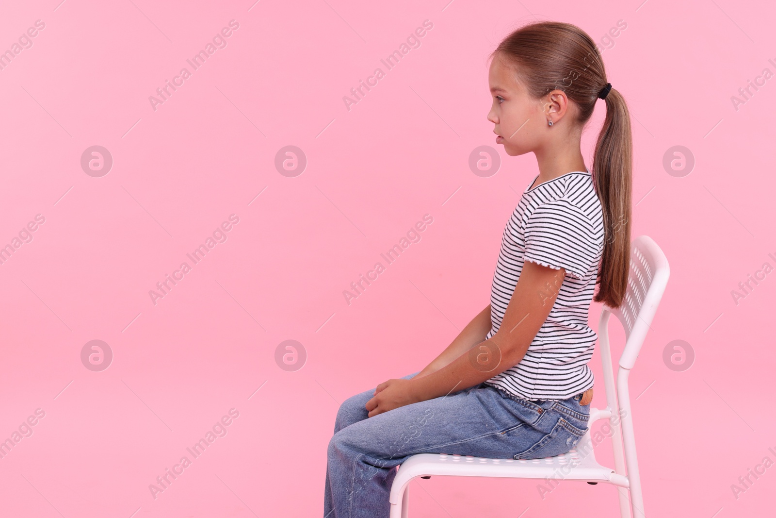 Photo of Girl with correct posture sitting on chair against pink background, space for text