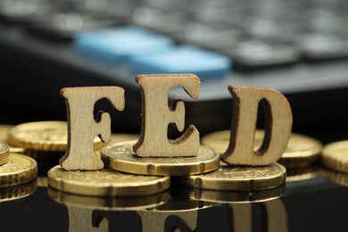 Photo of Word Fed (Federal Reserve System) made with letters and coins on dark mirror table