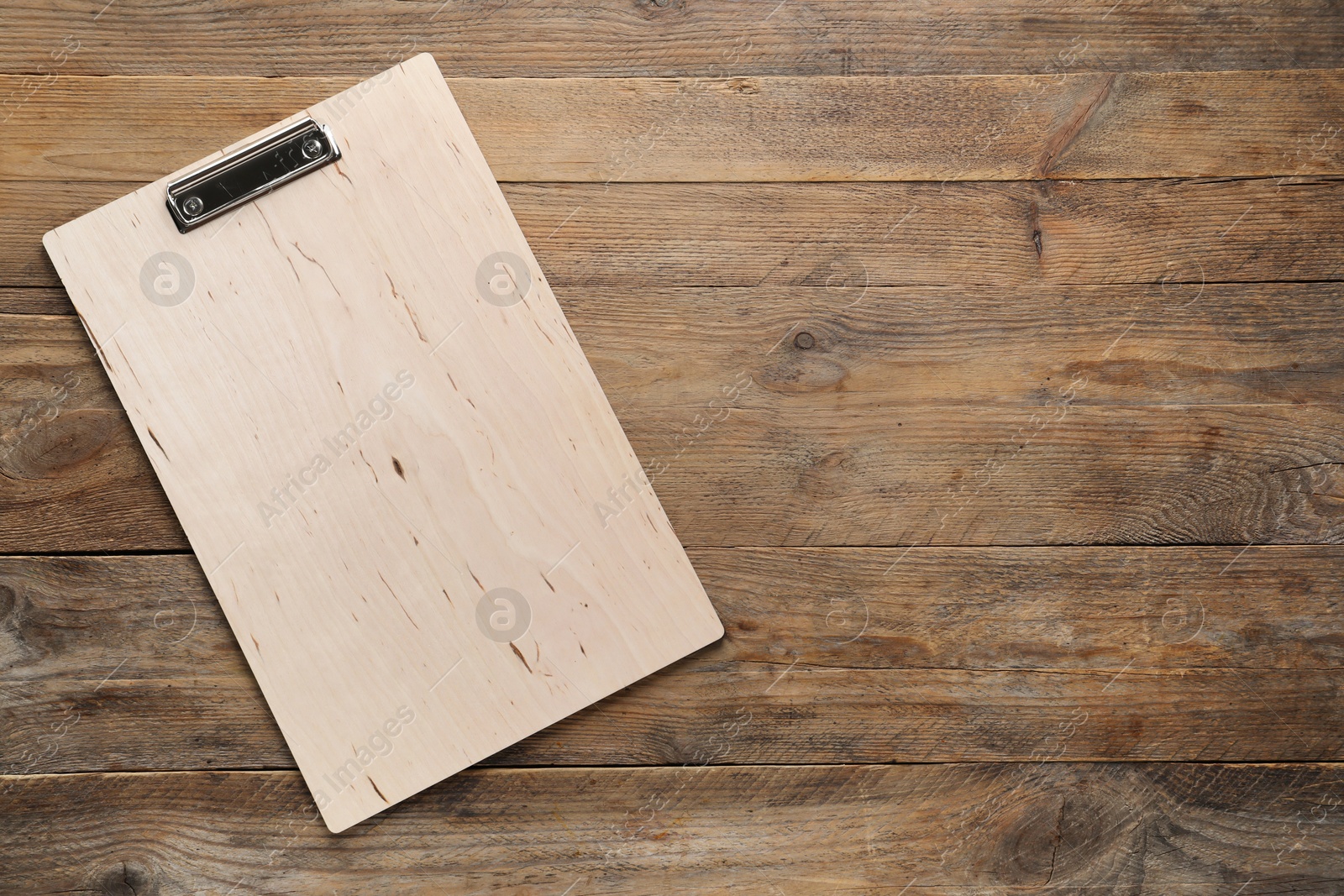 Photo of One clipboard on wooden table, top view. Space for text