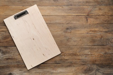 Photo of One clipboard on wooden table, top view. Space for text