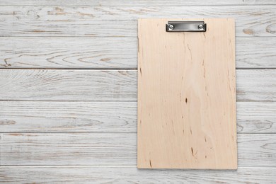 Photo of One clipboard on wooden table, top view. Space for text