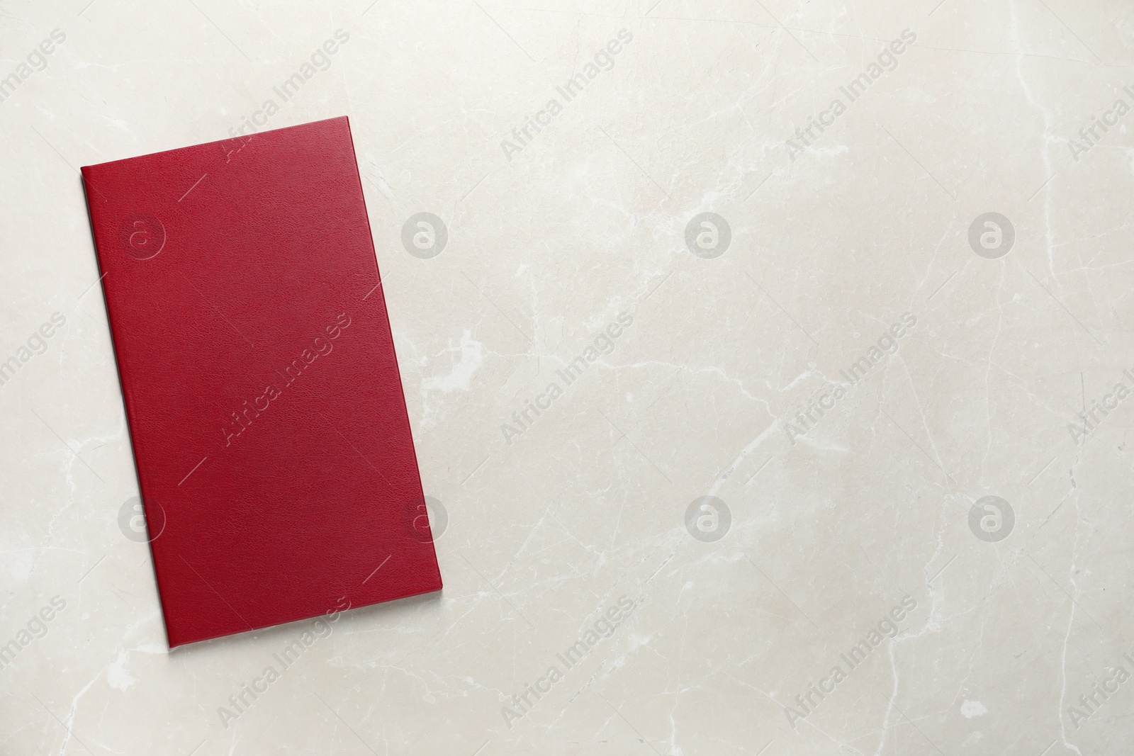 Photo of Hardcover book on light marble table, top view. Space for text