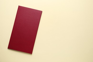 Photo of Hardcover book on beige background, top view. Space for text