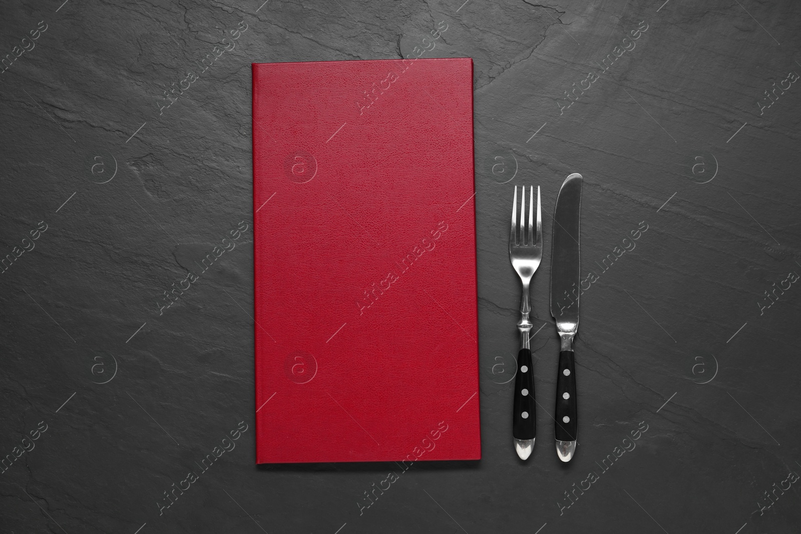 Photo of Hardcover menu and cutlery on grey textured table, flat lay