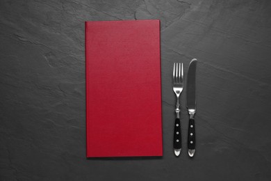 Photo of Hardcover menu and cutlery on grey textured table, flat lay