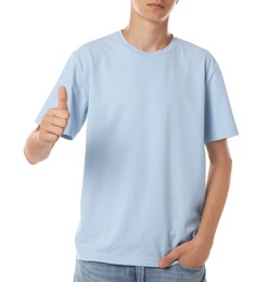 Teenage boy wearing light blue t-shirt and showing thumbs up on white background, closeup