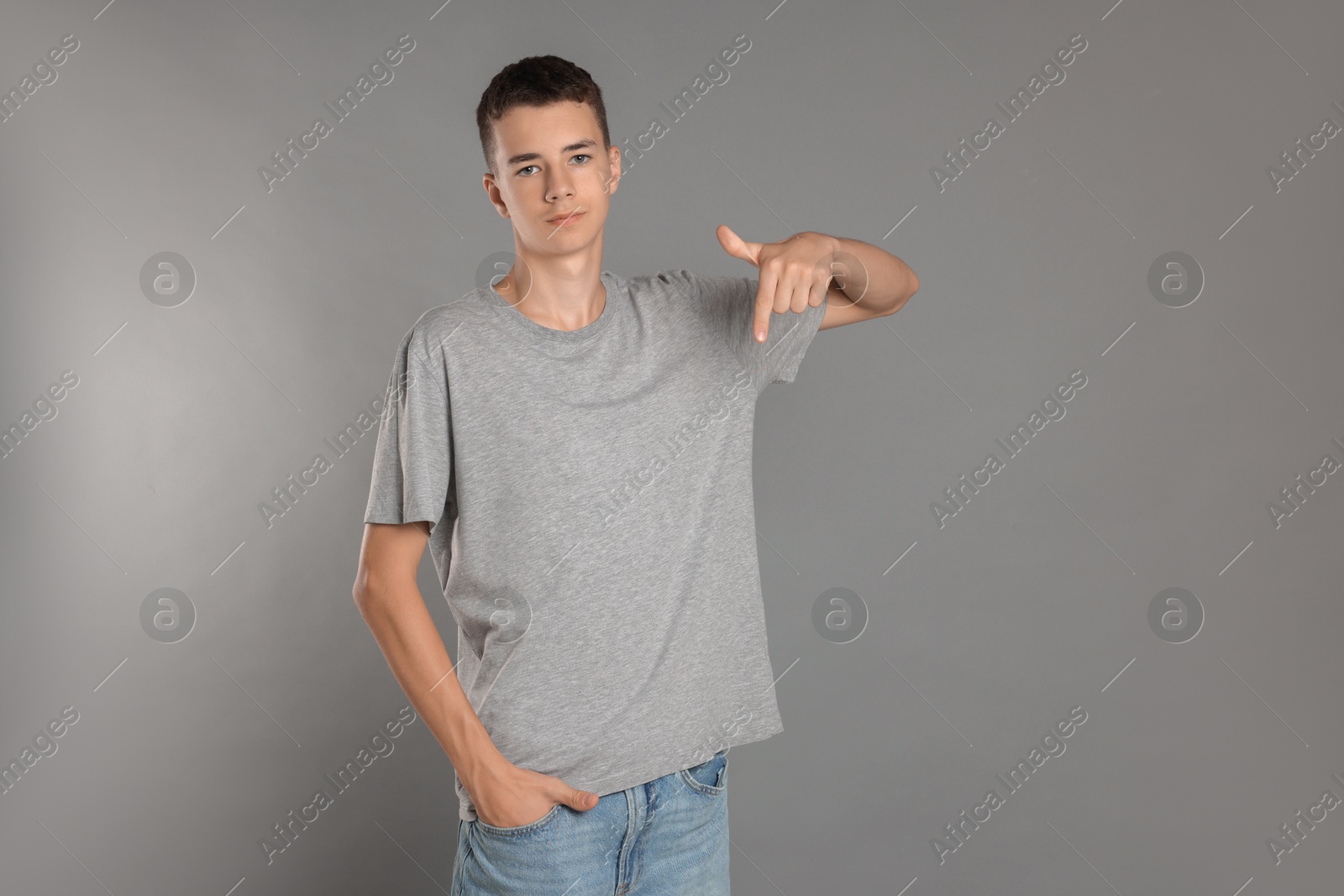 Photo of Teenage boy wearing t-shirt on grey background