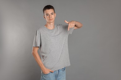 Photo of Teenage boy wearing t-shirt on grey background