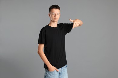 Photo of Teenage boy wearing black t-shirt on grey background