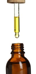 Photo of Dripping tincture from pipette into bottle on white background, closeup