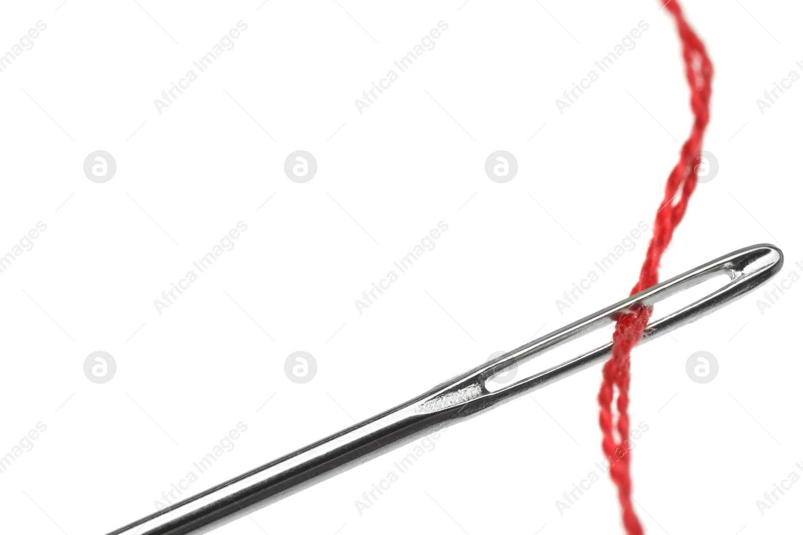 Photo of Sewing needle with red thread isolated on white, closeup