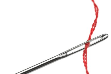 Sewing needle with red thread isolated on white, closeup