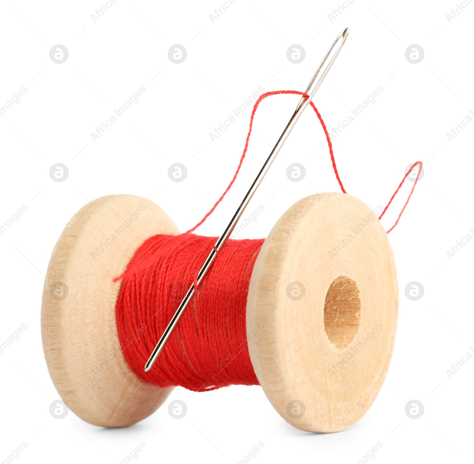 Photo of Spool of red sewing thread with needle isolated on white