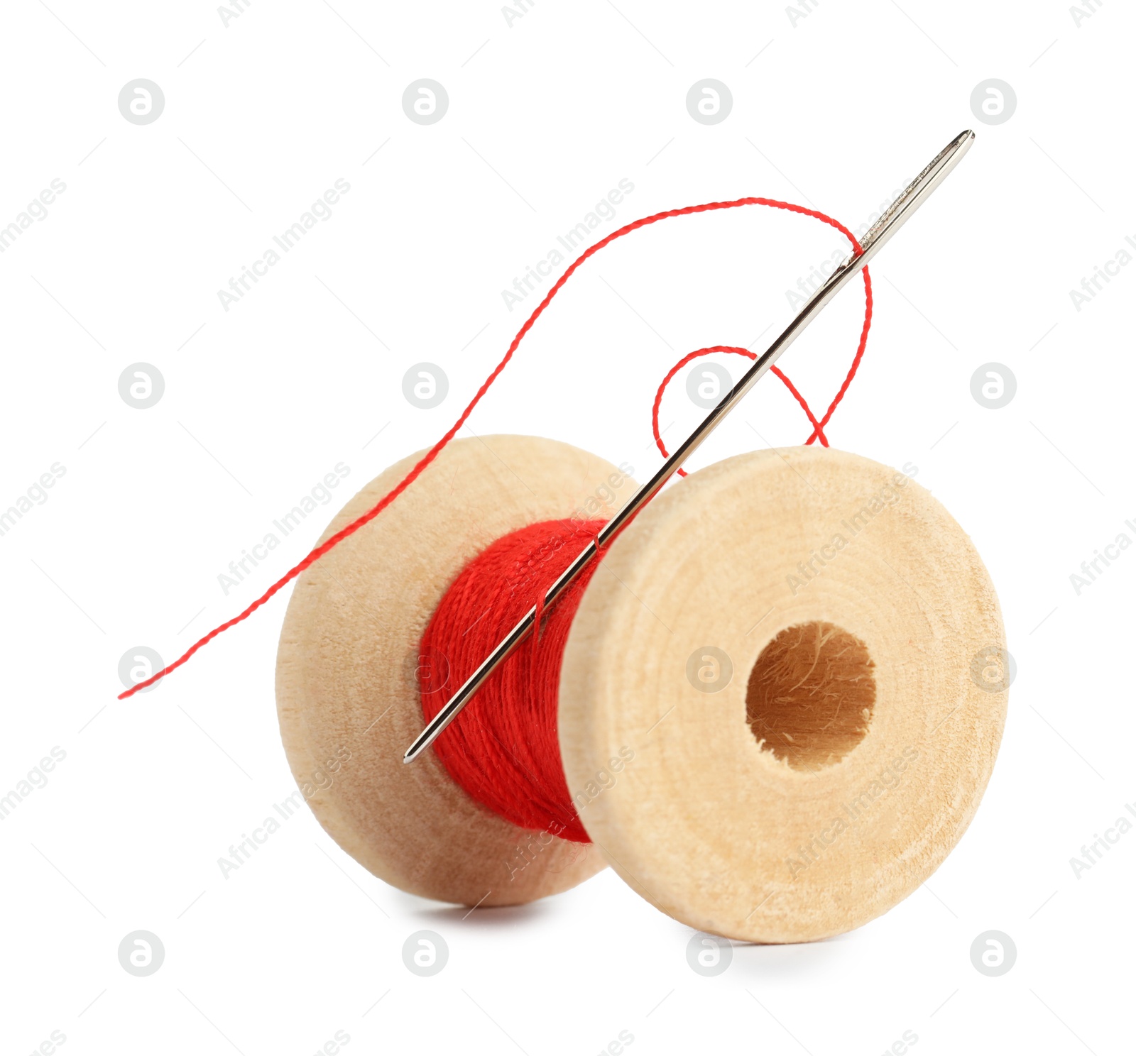 Photo of Spool of red sewing thread with needle isolated on white