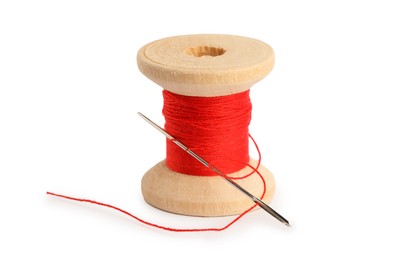 Photo of Spool of red sewing thread with needle isolated on white