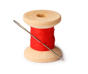 Spool of red sewing thread with needle isolated on white