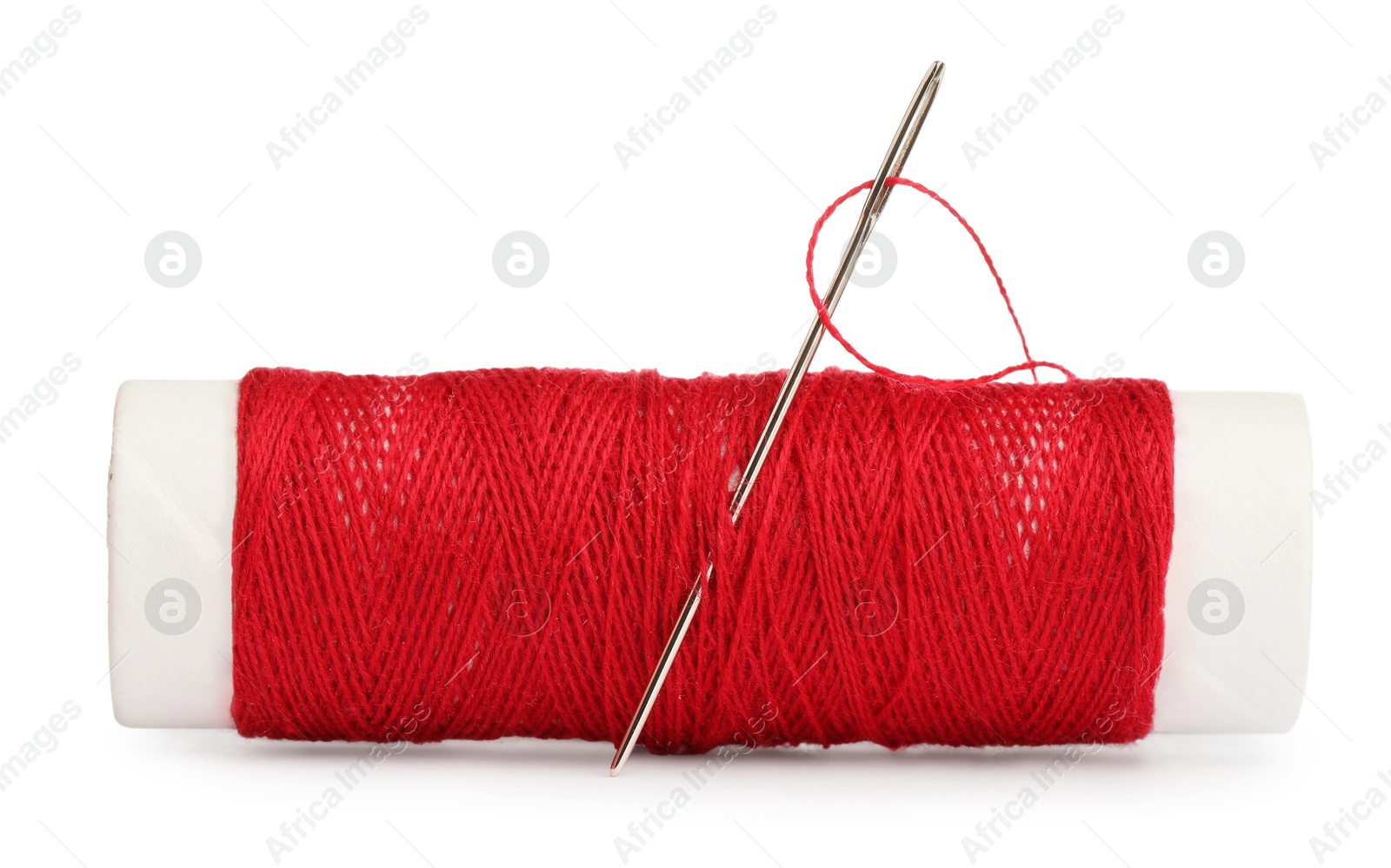 Photo of Spool of red sewing thread with needle isolated on white