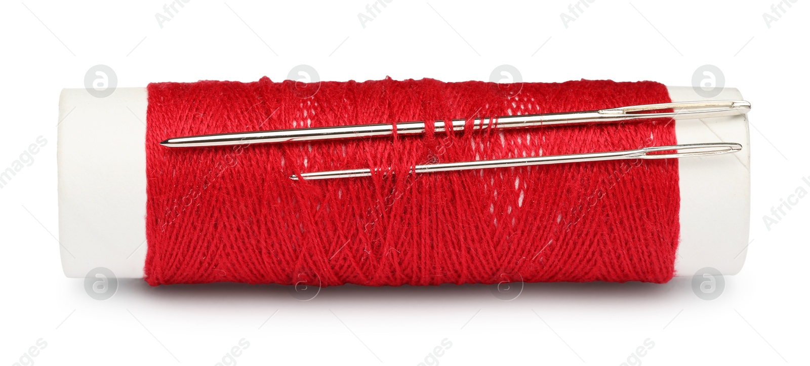 Photo of Spool of red sewing thread with needles isolated on white