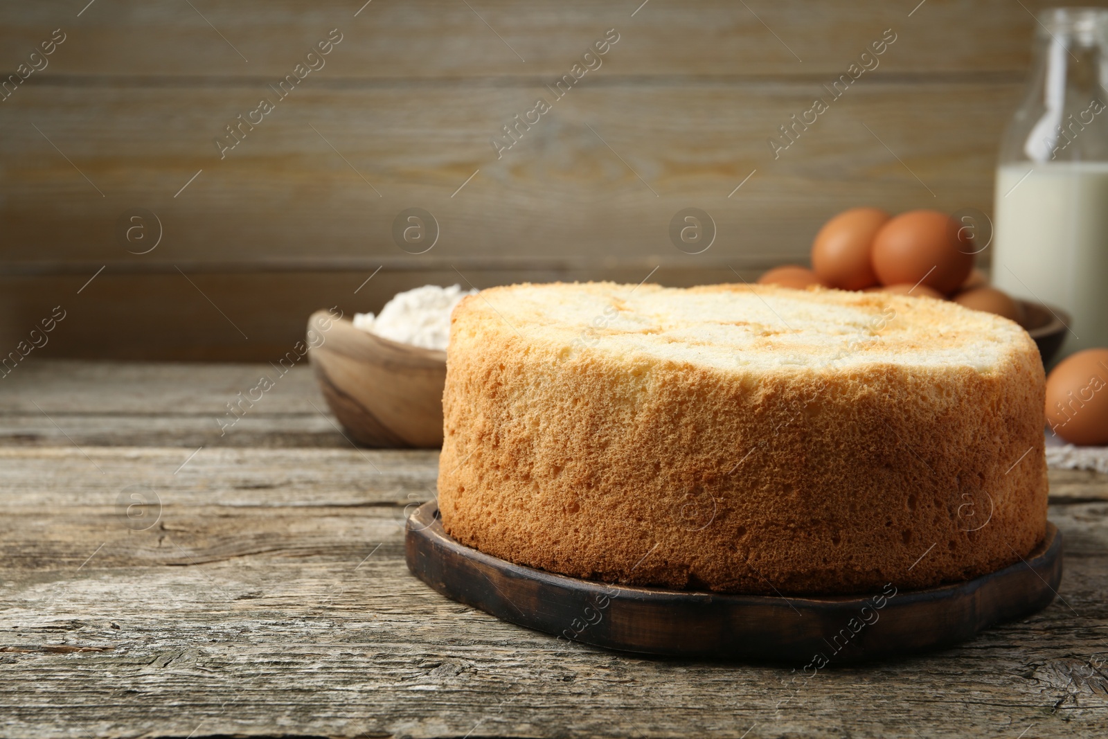 Photo of Tasty sponge cake on wooden table, space for text