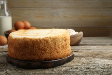 Photo of Tasty sponge cake on wooden table, space for text