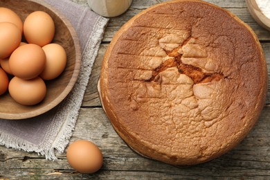 Photo of Tasty sponge cake and ingredients on wooden table, flat lay