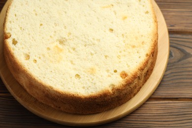 Photo of Tasty cut sponge cake on wooden table, top view