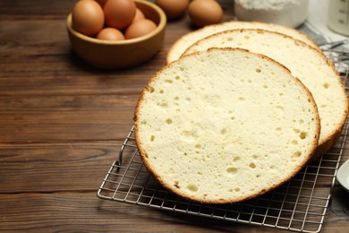 Photo of Tasty cut sponge cake and ingredients on wooden table